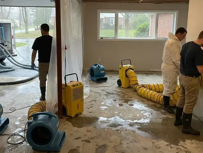 Air movers and a dehumidifier drying a flooded ground floor room