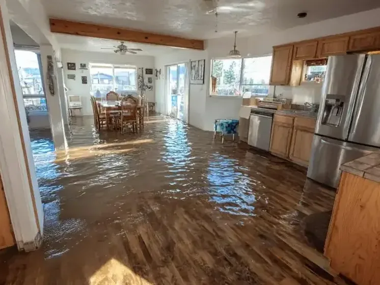 Floodwater spread across the kitchen and living area of a house after a storm