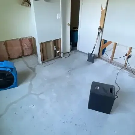 Air movers and a dehumidifier running in a room opened up for drying