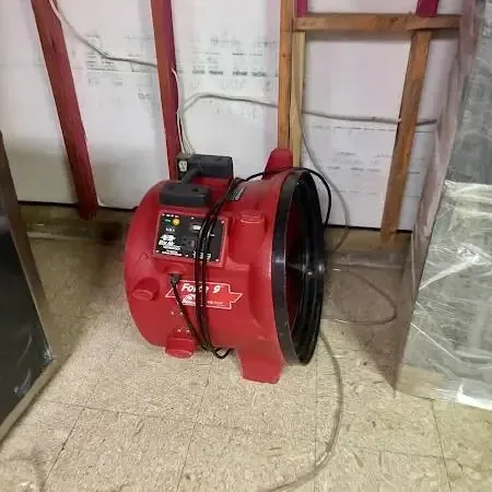 Drying equipment running in a living room after creek water entered a house