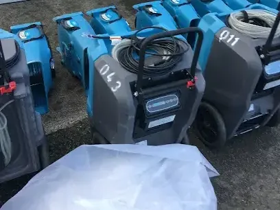 Rows of air movers and LGR dehumidifiers staged for a large commercial drying job