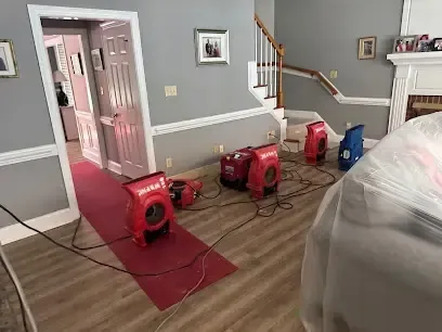 Air movers and a dehumidifier running across a wet wood floor